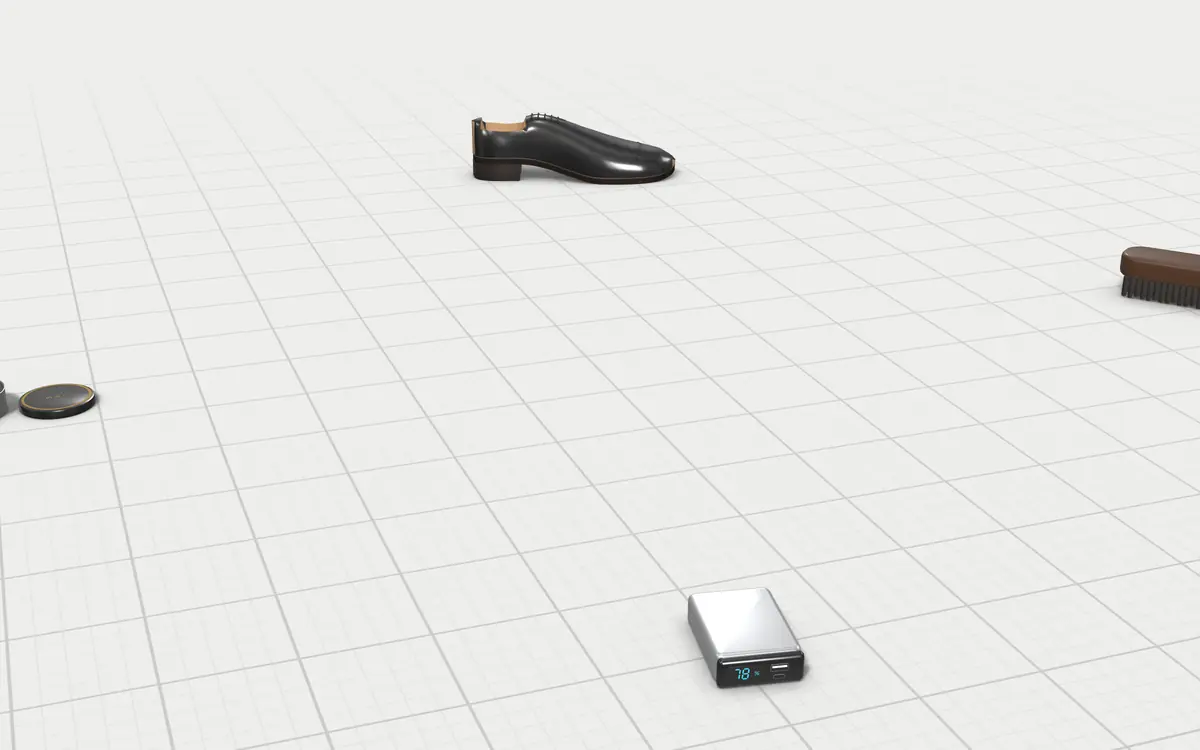 Illustration of the 5 electric shoe polishers to scale, next to a black oxford shoe, a horsehair brush, a tin of polish and a power bank for size